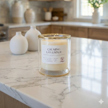 Load image into Gallery viewer, Candle labeled 'Calming Lavender' on a marble countertop in a kitchen.